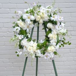White floral wreath on a green easel stand