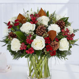 Bouquet of white roses and red flowers in a clear glass vase