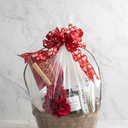 Gift basket with wine, candles, and a red heart ribbon