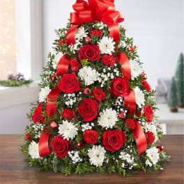 Tree-shaped floral arrangement with red roses, white daisies, and red ribbon bows
