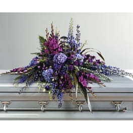 Purple and blue floral spray on a silver casket