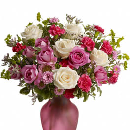 Pink and white rose bouquet in a frosted magenta vase