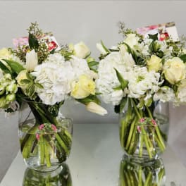Two white floral bouquets in clear glass vases