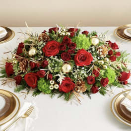 Red rose centerpiece with pinecones and gold ornaments on a table