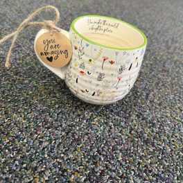 Floral-patterned ceramic mug with a hanging tag that says "you are amazing"