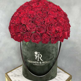 Large dome of red roses in a dark green hatbox