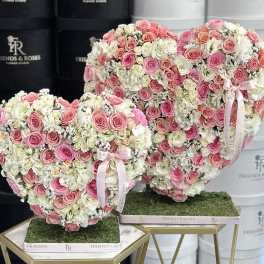 Heart-shaped rose arrangements in pink and white on gold stands