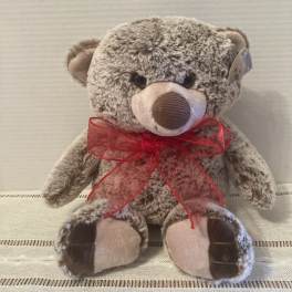 Plush teddy bear with a red ribbon bow