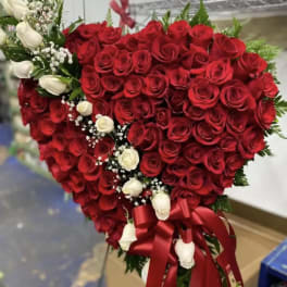 Heart-shaped bouquet of red and white roses with a red ribbon