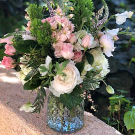 Pink and white floral arrangement in a textured glass vase
