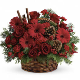 Red roses and gerbera daisies in a wicker basket with pinecones
