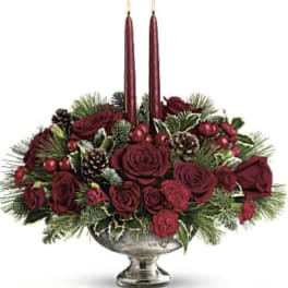 Red rose centerpiece with two tall burgundy candles in a silver bowl