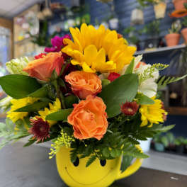Mixed bouquet in a yellow smiley-face mug