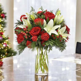 Red roses and white lilies arranged in a clear glass vase