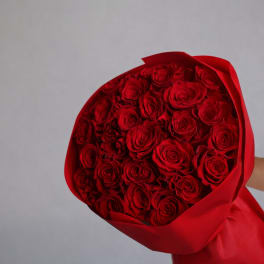 Bouquet of red roses wrapped in red paper