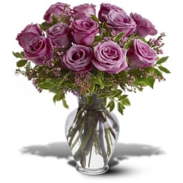 Bouquet of lavender roses with small pink blooms in a clear glass vase
