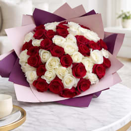 Bouquet of red and white roses wrapped in pink and purple paper