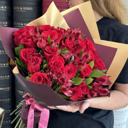 Bouquet of red roses and red alstroemeria wrapped in burgundy and gold paper