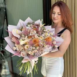 Woman holding a large pastel bouquet with roses and anthuriums