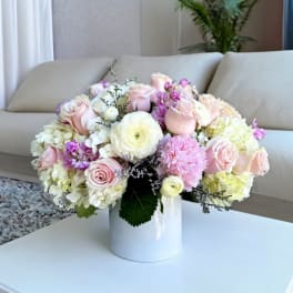 Pastel bouquet of roses, hydrangeas, and ranunculus in a white vase