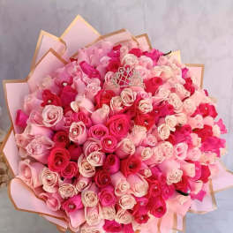Large bouquet of pink and red roses with a small tiara topper