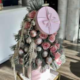 Pink roses arranged with ornaments in a pink hat box