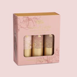 Pink boxed set of three jumbo lip tints with floral illustrations and a clear window.