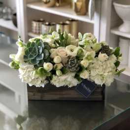 White floral arrangement with succulents in a wooden box