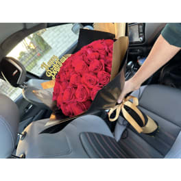 Bouquet of red roses with a gold "Happy Birthday" topper