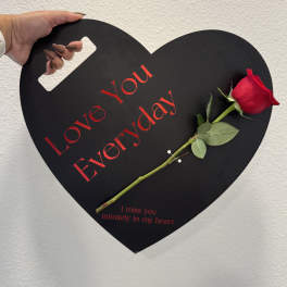 Black heart-shaped sign with a red rose and memorial text