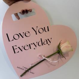 Pink heart-shaped sign with a white rose and the words Love You Everyday