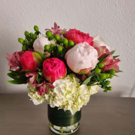 Pink and white peonies with hydrangeas in a glass vase