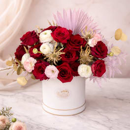 Red and white roses arranged in a white hat box