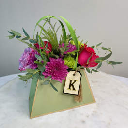 Mixed bouquet in a green gift box with a letter tag