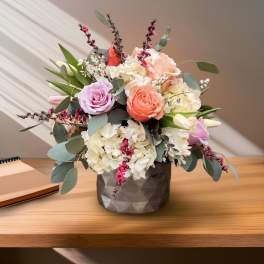 Mixed bouquet of roses and hydrangeas in a dark vase