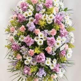 Large standing spray of pink roses, white daisies, and pastel flowers