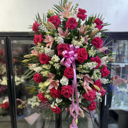 Standing floral spray with pink roses, lilies, and white filler flowers