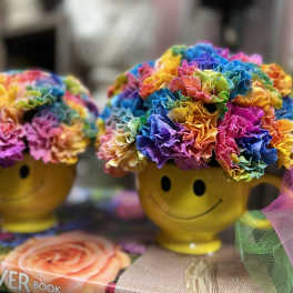 Rainbow flower arrangements in yellow smiley-face mugs