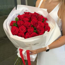 Bouquet of red roses wrapped in white paper with a red ribbon