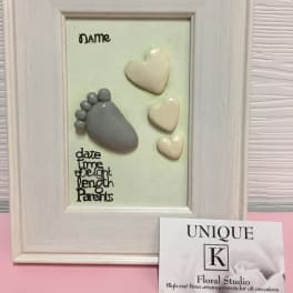 Framed keepsake with baby footprints and heart shapes