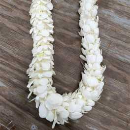 White flower lei on a wooden surface