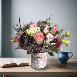 Mixed bouquet of pink and white flowers in a rustic vase