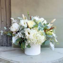 White floral arrangement in a white cylindrical vase