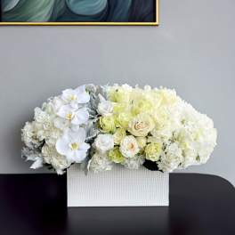 White floral arrangement in a textured rectangular box
