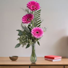 Tall bouquet of pink gerbera daisies in a glass vase