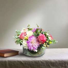 Mixed pink and white flowers arranged in a glass bowl vase