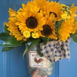 Sunflower bouquet in a metal flour tin with a plaid bow