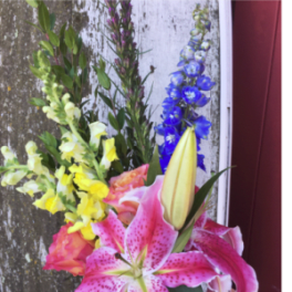 Bouquet with pink lilies, yellow snapdragons, and blue delphinium