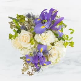 Bouquet of white roses and purple irises with small accent flowers