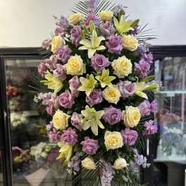 Tall standing floral spray with lavender roses and pale yellow lilies